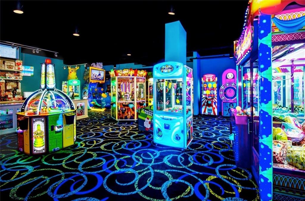 An indoor arcade room features various gaming machines on a patterned, glow-in-the-dark carpet — 14501 GROVE RESORT AVENUE UNIT 1440, WINTER GARDEN, FL
