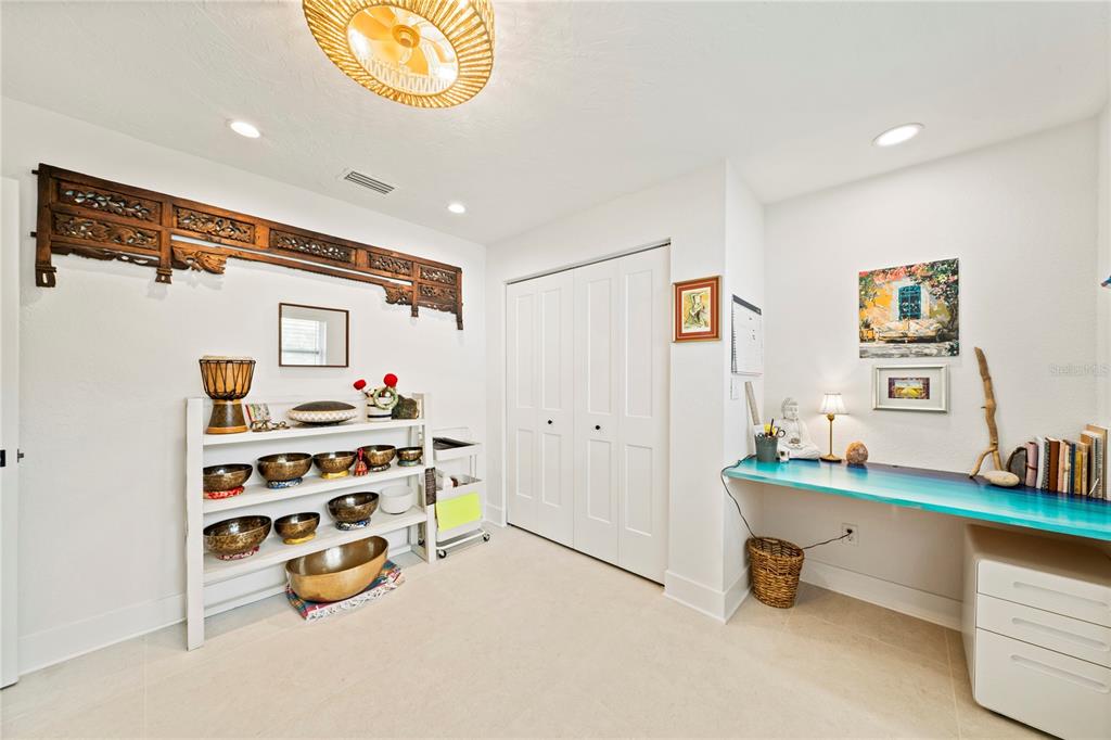 A room with white walls, tile flooring, a shelving unit with bowls, and a built-in desk — 1924 MICHIGAN AVENUE NE, ST PETERSBURG, FL
