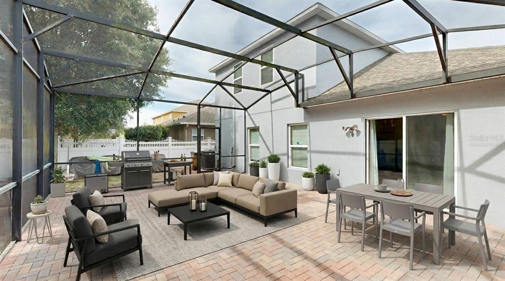 A screened-in patio features a brick paver floor, outdoor furniture, and a grill — 16337 SAINT AUGUSTINE STREET, CLERMONT, FL
