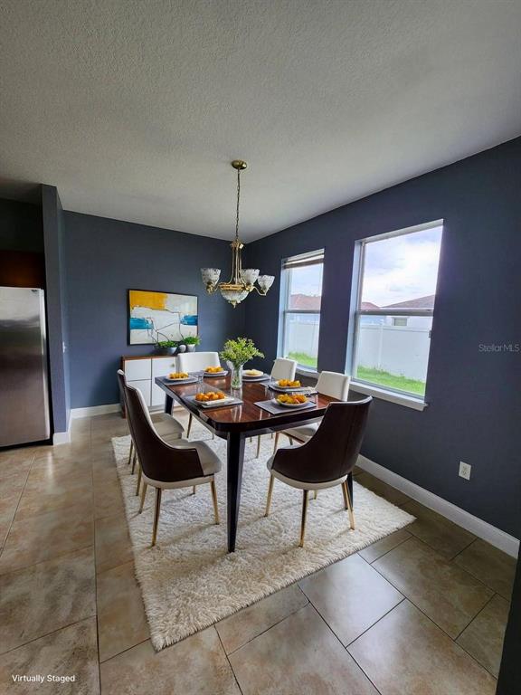 A dining room features dark blue walls, a wooden table with six chairs, and tile flooring — 328 DUNDEE DRIVE, KISSIMMEE, FL