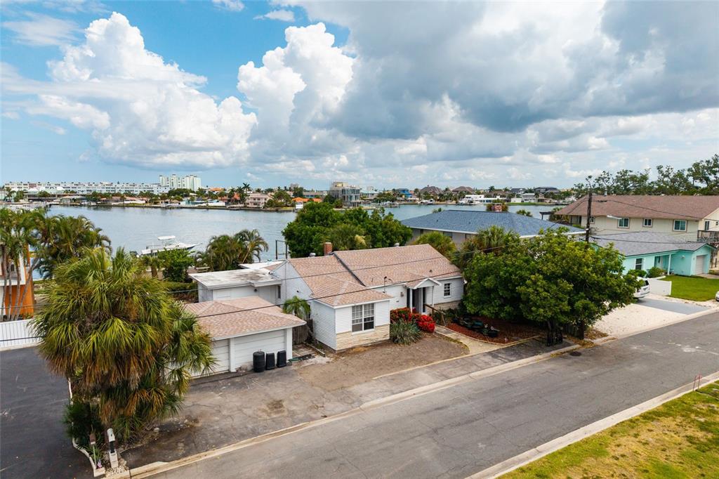 An aerial view of a single-story house with a shingled roof near a waterfront — 216 PUNTA VISTA DRIVE, ST PETE BEACH, FL