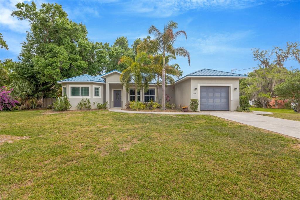 A single-story house with a blue metal roof, gray exterior, and a one-car garage — 2936 SE NORMAN AVENUE, ARCADIA, FL