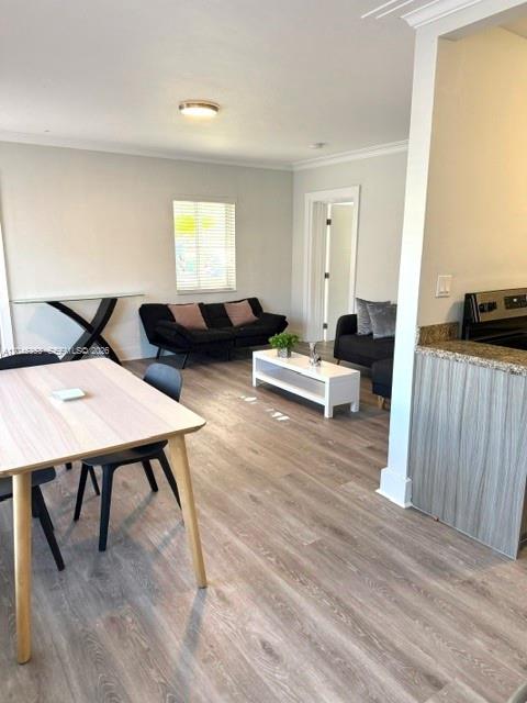 A dining area and living room feature light wood-look flooring and a modern open layout — 345 85 # 1, Miami Beach FL 33141, MIAMI BEACH, FL