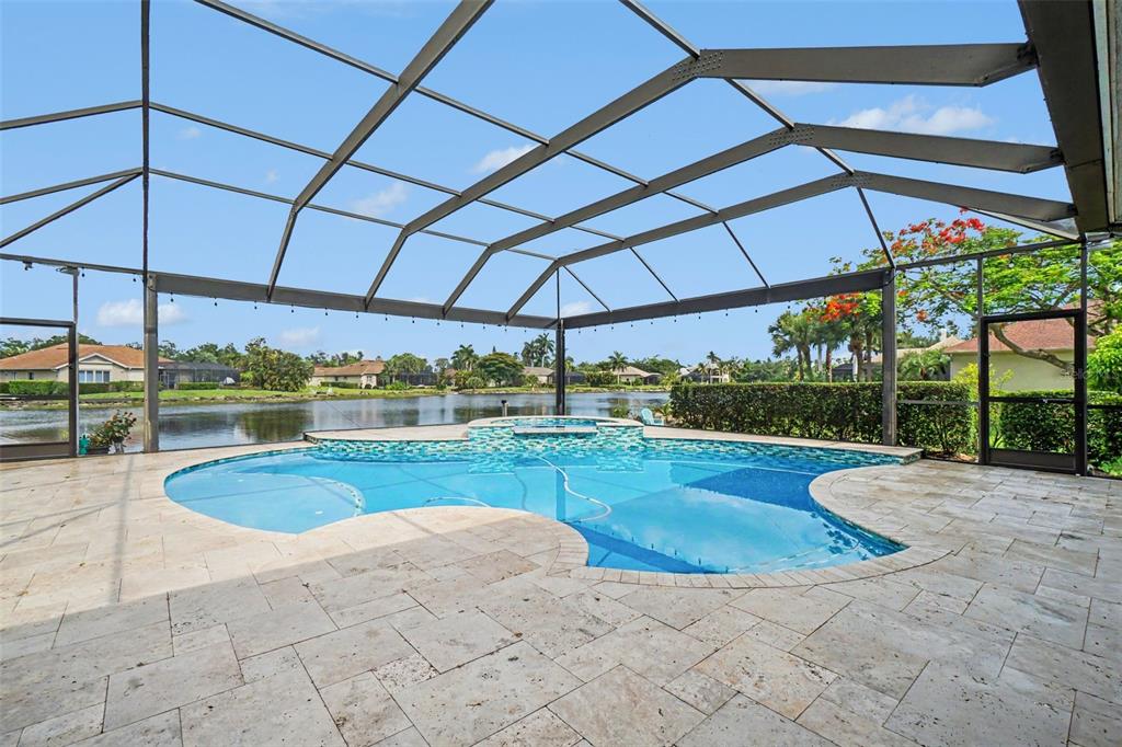 A single-story brick and stucco house with a manicured lawn and palm trees — 15220 BLACKHAWK DRIVE, FORT MYERS, FL