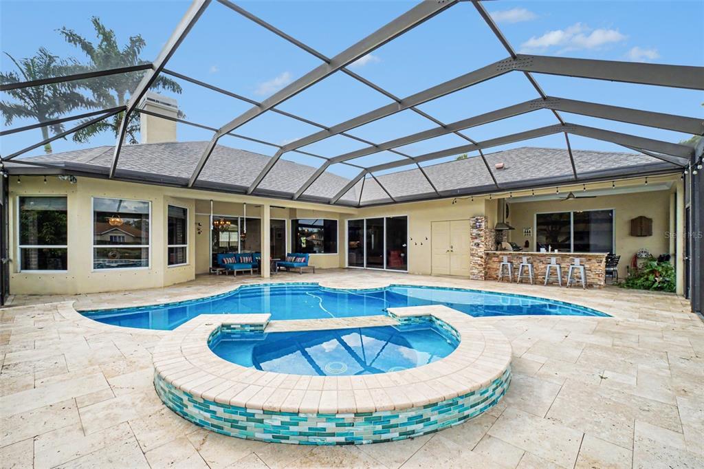 An aerial view of a single-story house with a shingled roof and a waterfront backyard — 15220 BLACKHAWK DRIVE, FORT MYERS, FL