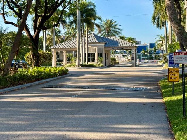 A gated entrance with a guardhouse and speed bumps leads to a residential community — 21 Royal Palm Way # 2020, Boca Raton FL 33432, BOCA RATON, FL