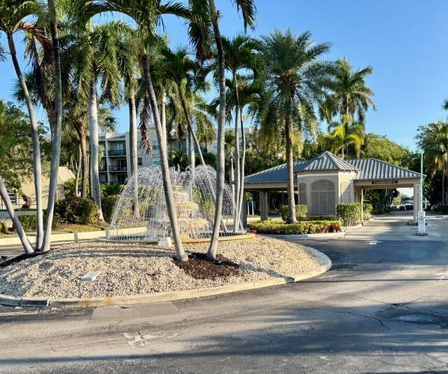 A fountain sits in a landscaped roundabout in front of a gated community entrance — 21 Royal Palm Way # 2020, Boca Raton FL 33432, BOCA RATON, FL