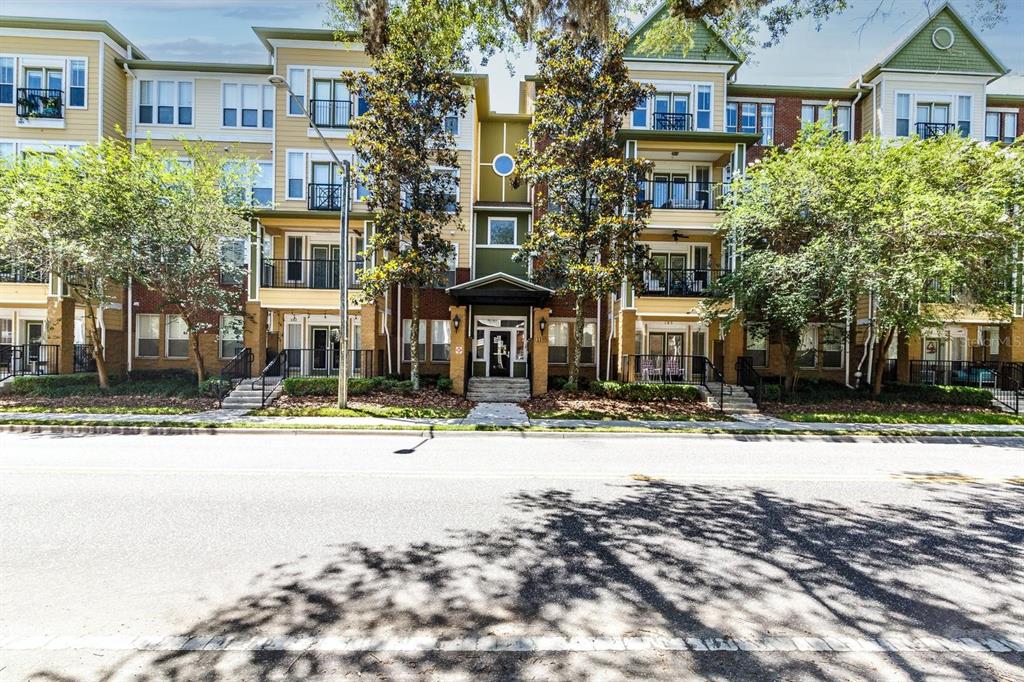 A multi-story apartment building with balconies, brick and siding exterior, and a central entrance — 1185 SW 9TH ROAD UNIT 212, GAINESVILLE, FL