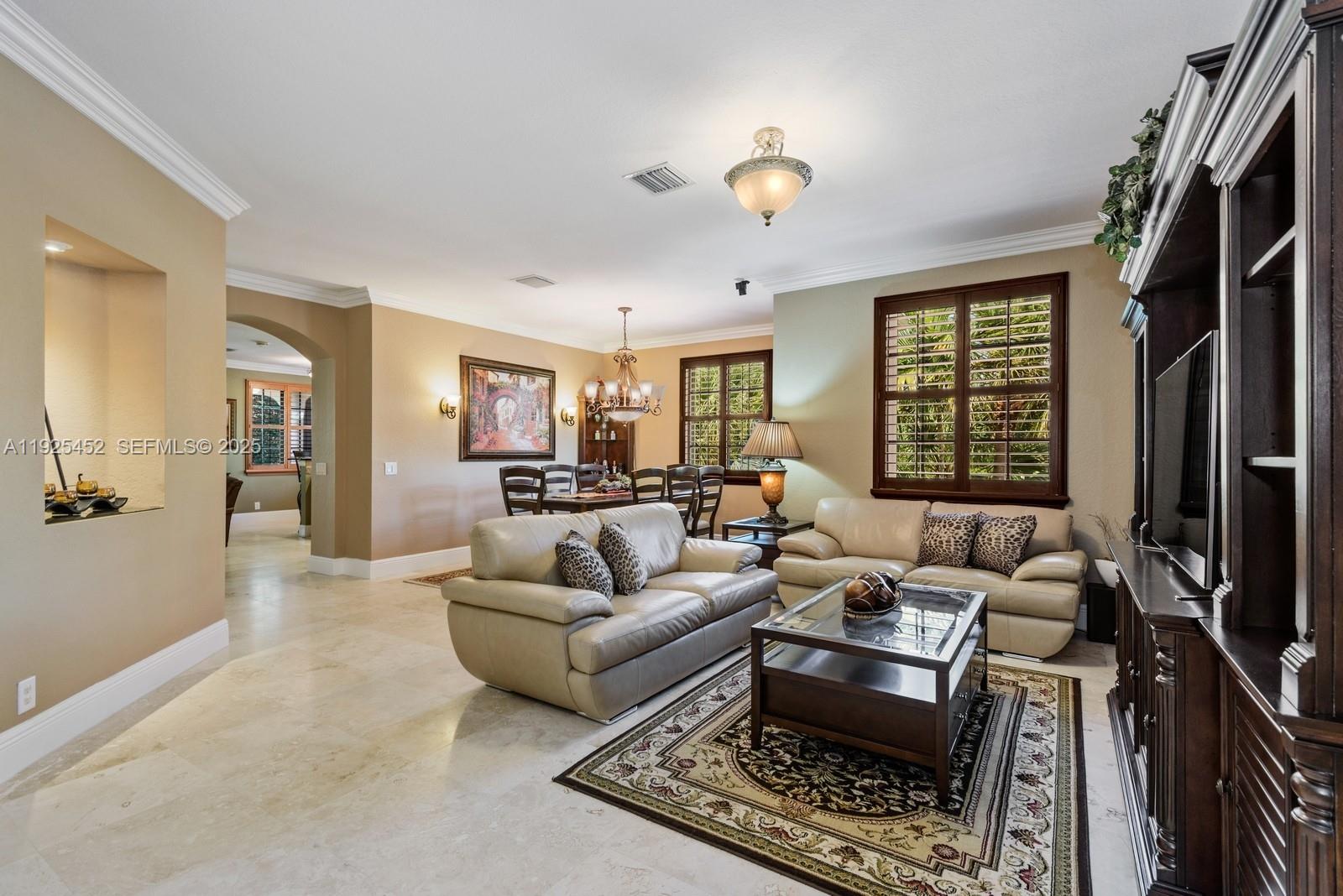A living room with beige leather sofas, a glass coffee table, and a dining area — 2782 Kinsington Cir # 4, Weston FL 33332, WESTON, FL