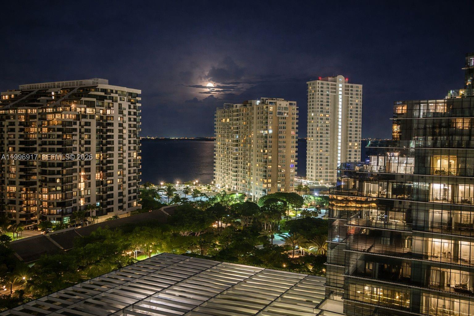 An elevated night view of high-rise apartment buildings overlooking a bay and park area — 701 Brickell Key Blvd # 1611, Miami FL 33131, MIAMI, FL