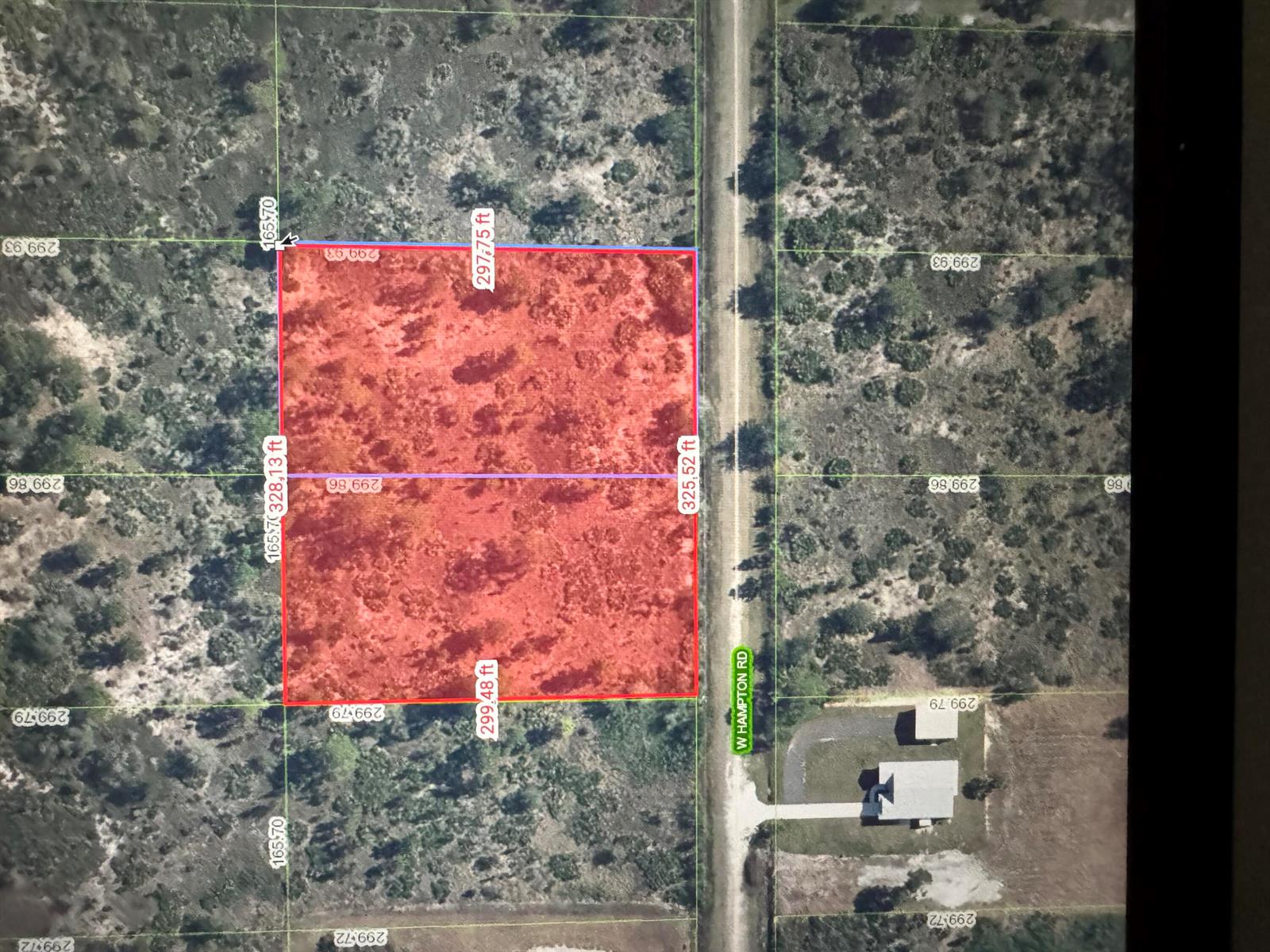This aerial map shows a rectangular plot of land highlighted in red along a road — 2050 W Hampton Road, FL 33825, FL