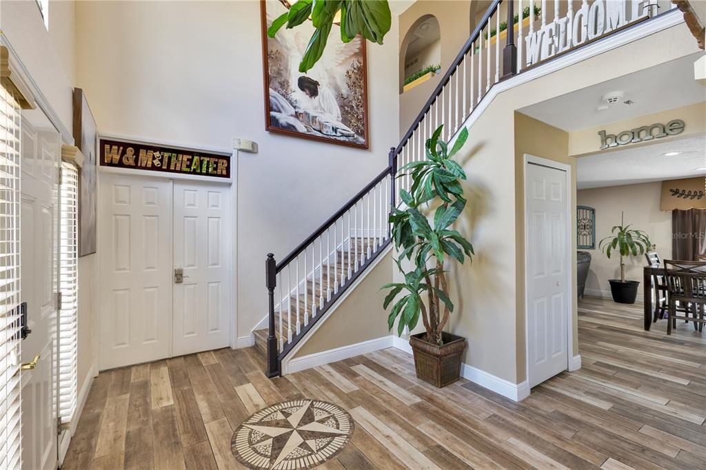An entryway features wood-look tile flooring, a staircase with a dark railing, and a double door — 5051 PLYMOUTH TURTLE CIRCLE, ST CLOUD, FL