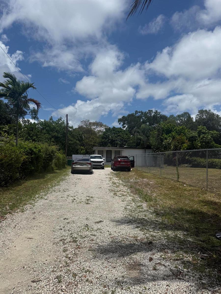 A gravel driveway leads to a small house with three parked cars in front — 6315 SW 32nd Street, Miramar FL 33023, MIRAMAR, FL