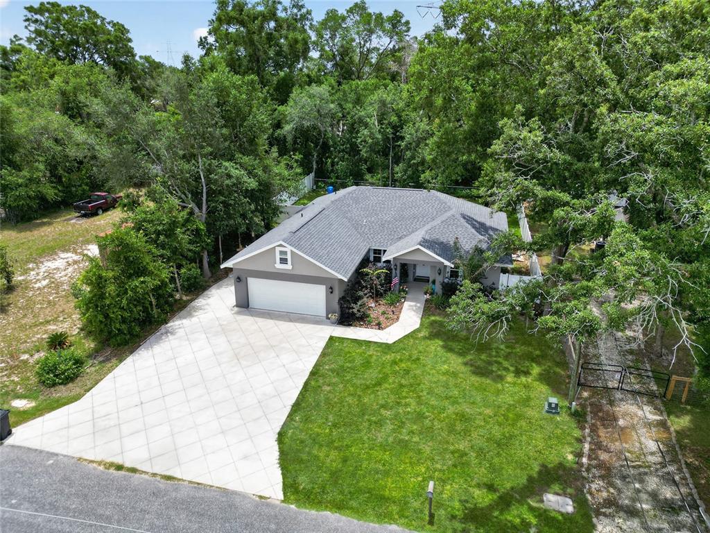 An aerial view shows a single-story house with a gray roof, garage, and large lawn — 8160 SE 164TH PLACE, SUMMERFIELD, FL