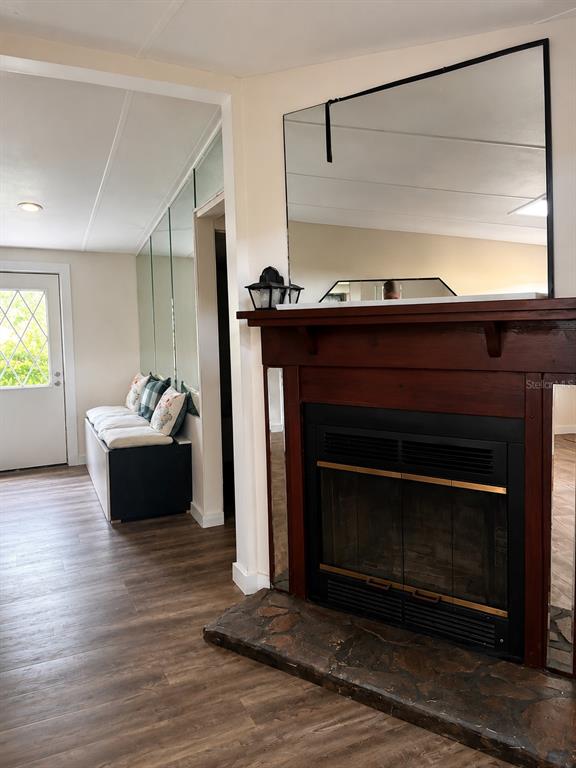 A living room features a stone-hearth fireplace with a wood mantel and a large mirror — 25256 RICHBARN ROAD, BROOKSVILLE, FL