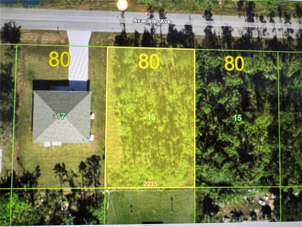 This is an aerial map showing a vacant rectangular lot highlighted in yellow — 23369 AVACADO AVENUE, PUNTA GORDA, FL