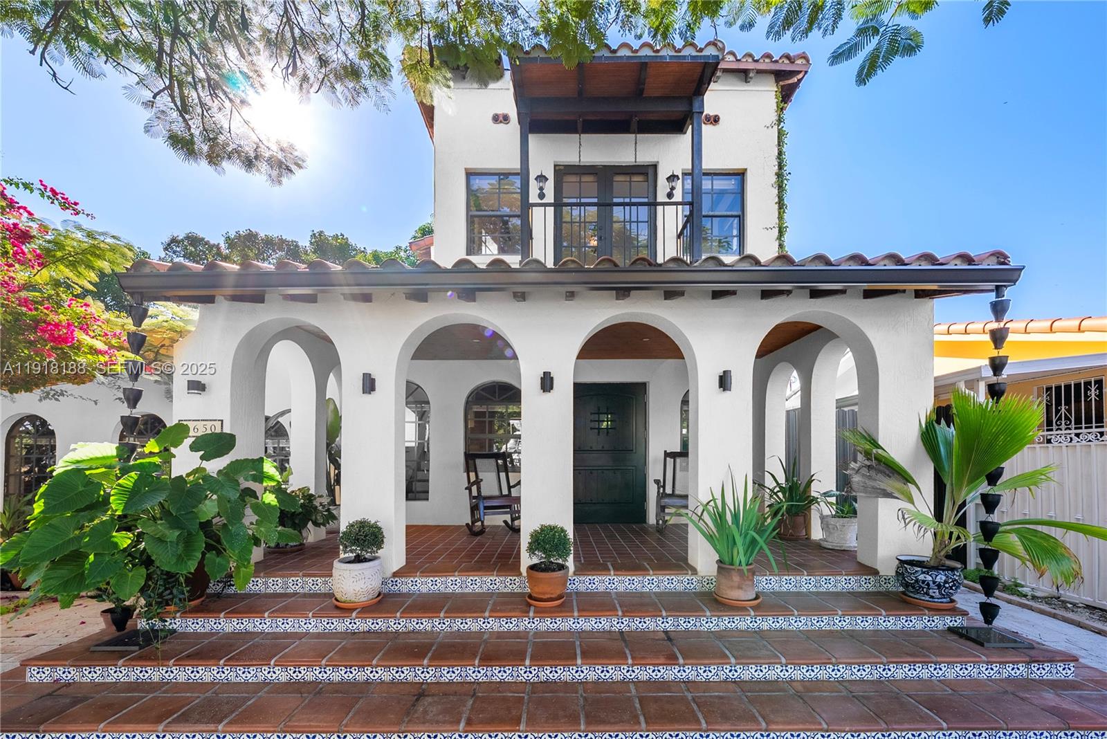 A white two-story house features a covered front porch with arched openings and tiled steps — 1650 SW 16th St, Miami FL 33145, MIAMI, FL