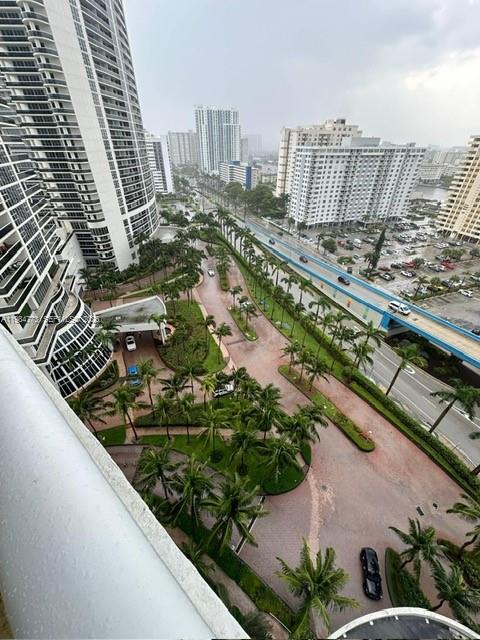 An elevated view shows a high-rise building overlooking a tropical courtyard and a nearby highway — 1800 S Ocean Dr # 1606, Hallandale Beach FL 33009, HALLANDALE BEACH, FL