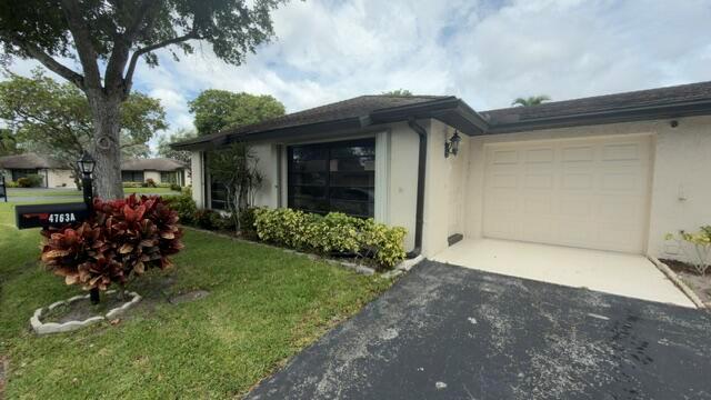A single-story house with a white stucco exterior, a garage, and a landscaped front yard — 4763 Storkwood Terrace # A, Boynton Beach FL 33436, BOYNTON BEACH, FL