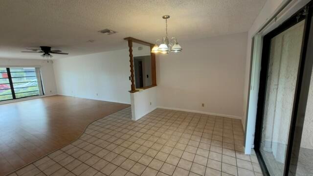 An open-concept living and dining area features tile flooring, wood laminate, and a decorative partition — 4763 Storkwood Terrace # A, Boynton Beach FL 33436, BOYNTON BEACH, FL