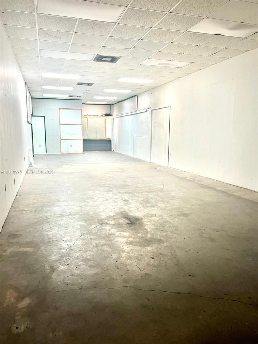 An empty commercial space features white walls, a drop ceiling, and a concrete floor — 11710 NW South River Dr, Medley FL 33178, MEDLEY, FL