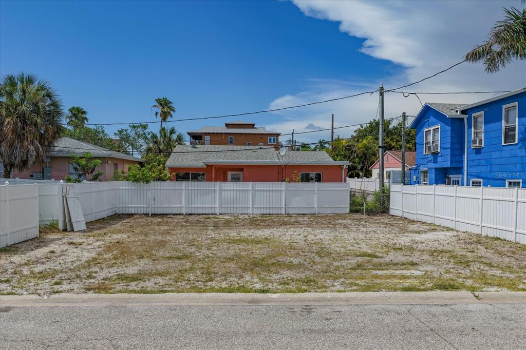 A vacant, sandy residential lot is enclosed by a white vinyl fence — 122 87TH AVENUE, TREASURE ISLAND, FL
