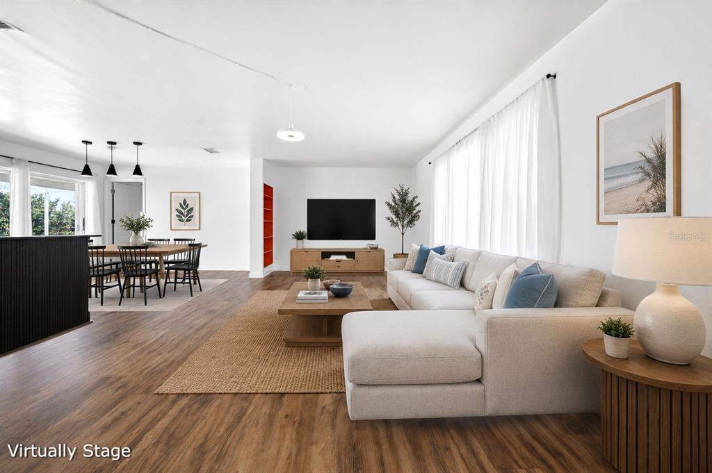 A living room with wood-look flooring, a sectional sofa, and an adjacent dining area — 1433 SE 28TH TERRACE, CAPE CORAL, FL