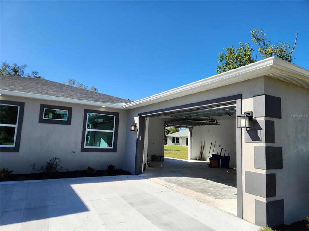 A view of a house exterior featuring a garage, concrete driveway, and gray trim — 1259 KAAYAN STREET, NORTH PORT, FL