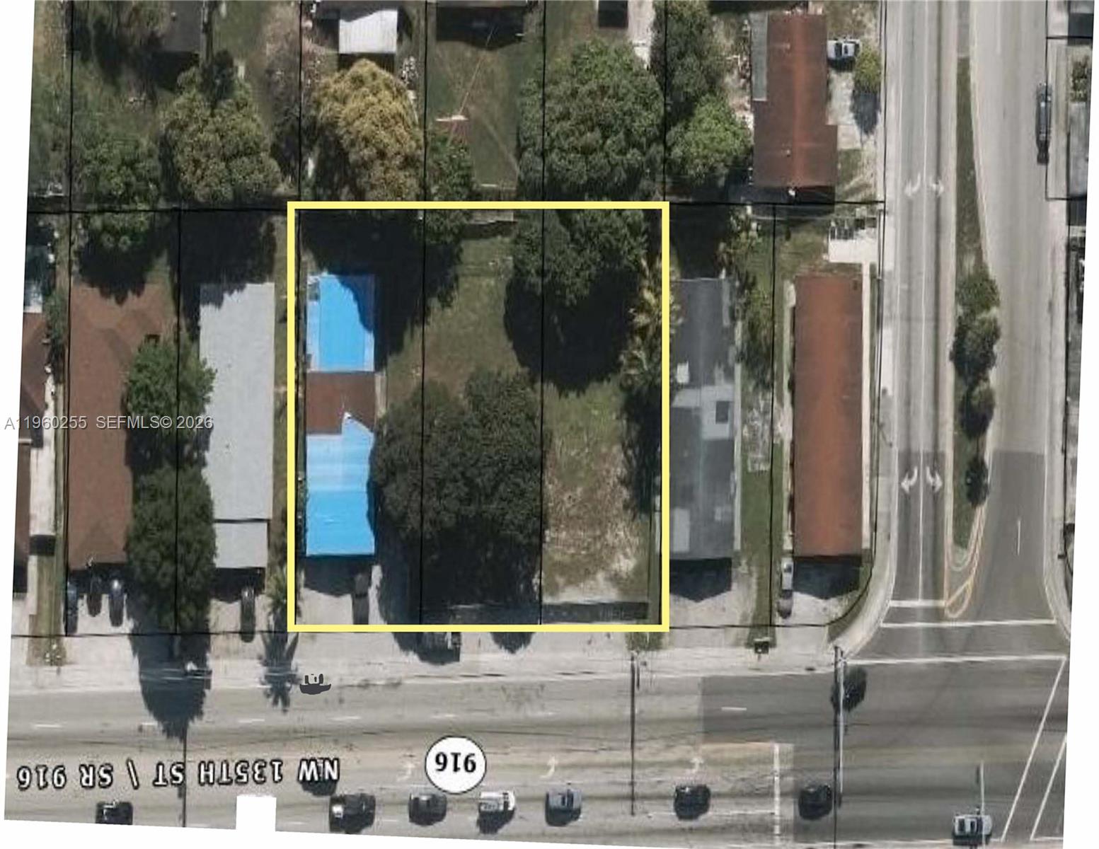 An aerial view shows a rectangular property lot with a building featuring a blue roof — 3160 NW 135th St, Opa-Locka FL 33054, OPA-LOCKA, FL