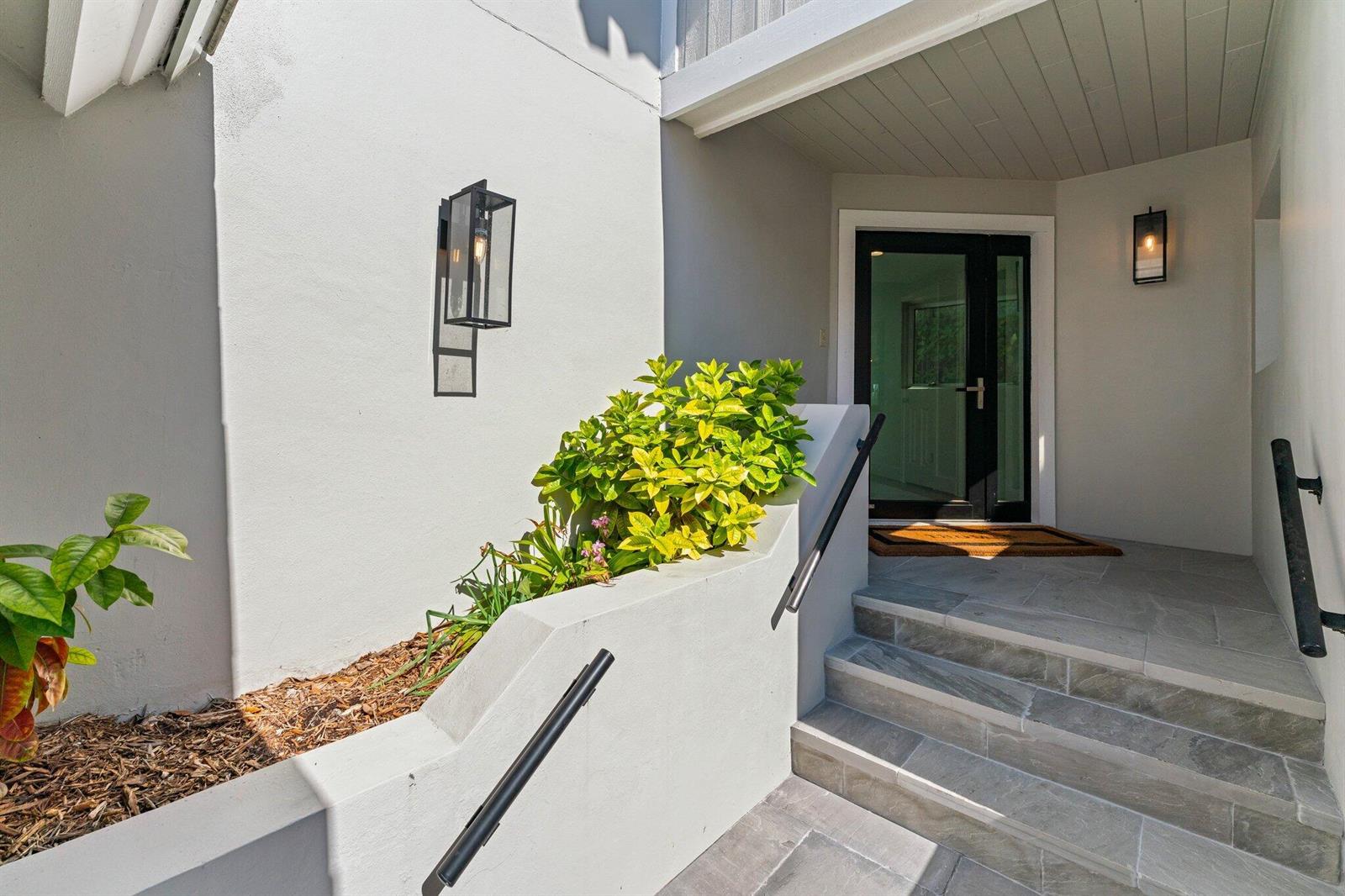 A concrete staircase with black handrails leads to a glass-paneled front door — 18760 SE Pineneedle Lane, Jupiter FL 33469, JUPITER, FL
