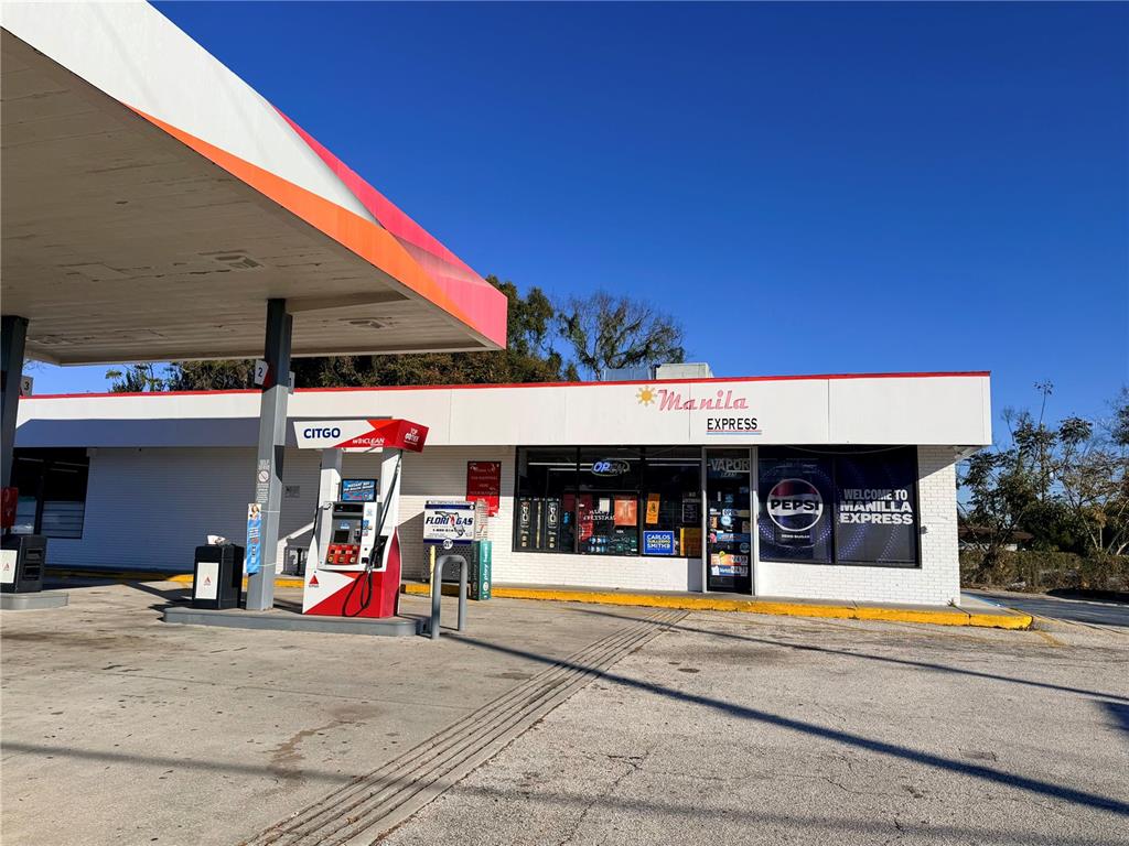 A Manila Express convenience store and Citgo gas station stand under a bright blue sky — 8431 E COLONIAL DRIVE, ORLANDO, FL