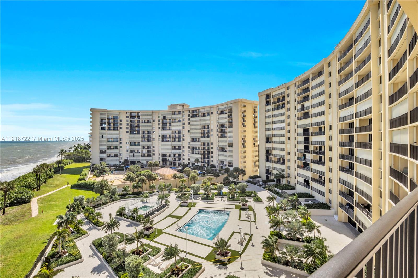 An elevated view shows a swimming pool area surrounded by large residential apartment buildings — 200 Ocean Trail Way # 609, Jupiter FL 33477, JUPITER, FL
