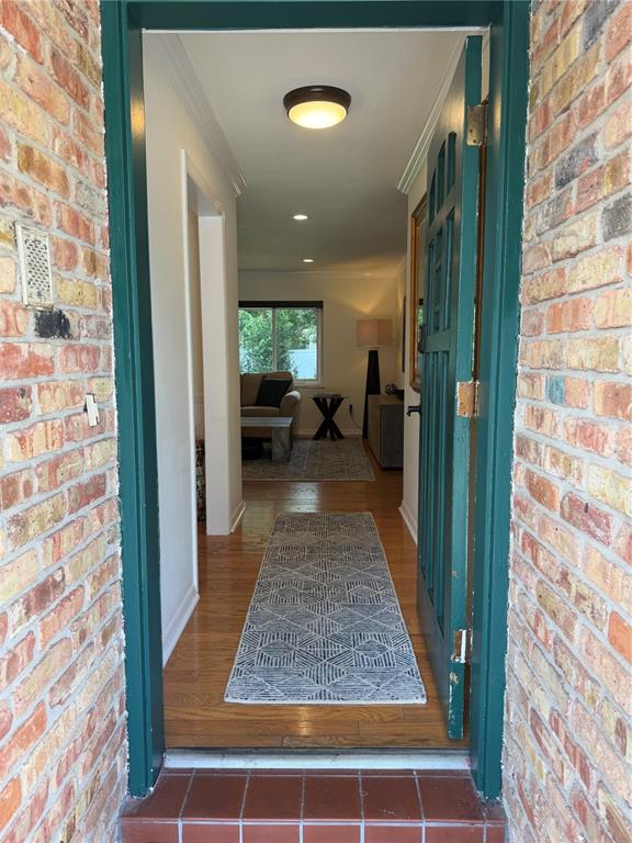 A view through an open green door into a hallway with hardwood floors and rugs — 810 SWEETBRIAR ROAD, ORLANDO, FL