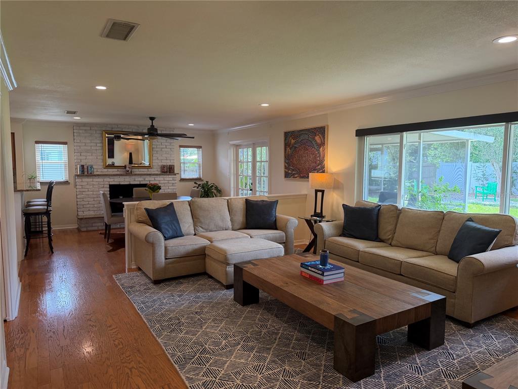 A living room with beige sofas, a wooden coffee table, and a white brick fireplace — 810 SWEETBRIAR ROAD, ORLANDO, FL