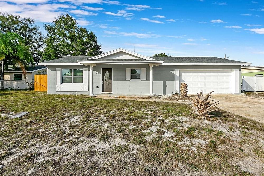 A single-story gray house with a white garage door and a front-facing gable roof — 4823 KATHY JO TERRACE, ORLANDO, FL