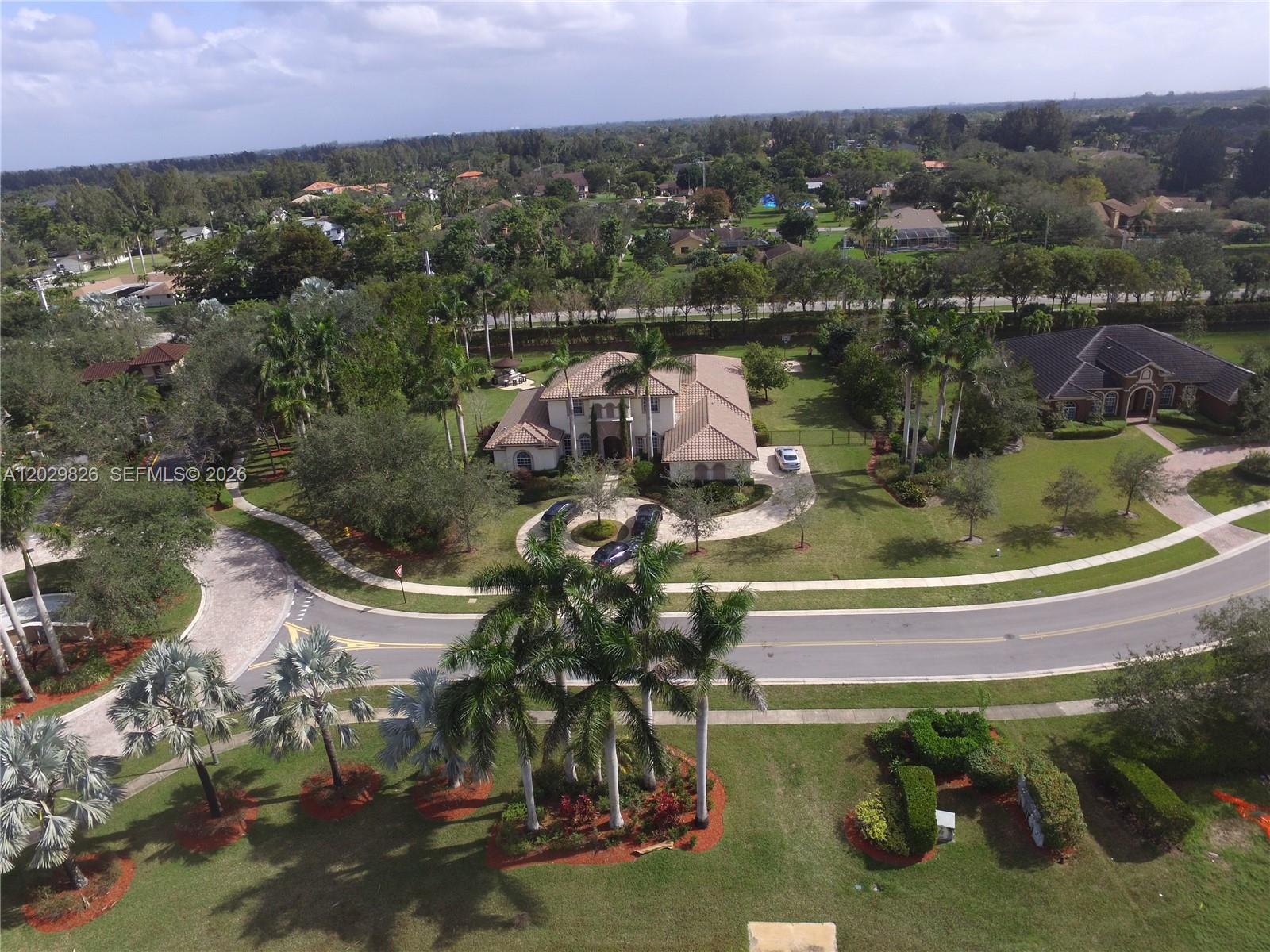 An aerial view shows a large suburban house with a circular driveway and palm trees — 2750 E Jockey Cir E, Davie FL 33330, DAVIE, FL