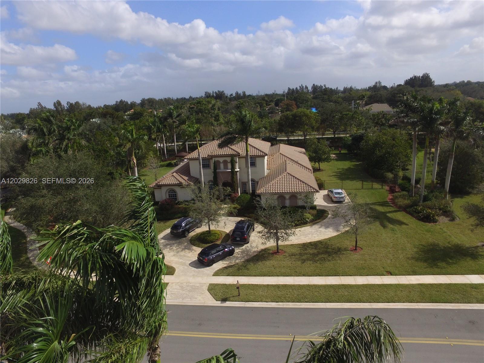 An aerial view shows a two-story house with a tile roof and a circular driveway — 2750 E Jockey Cir E, Davie FL 33330, DAVIE, FL