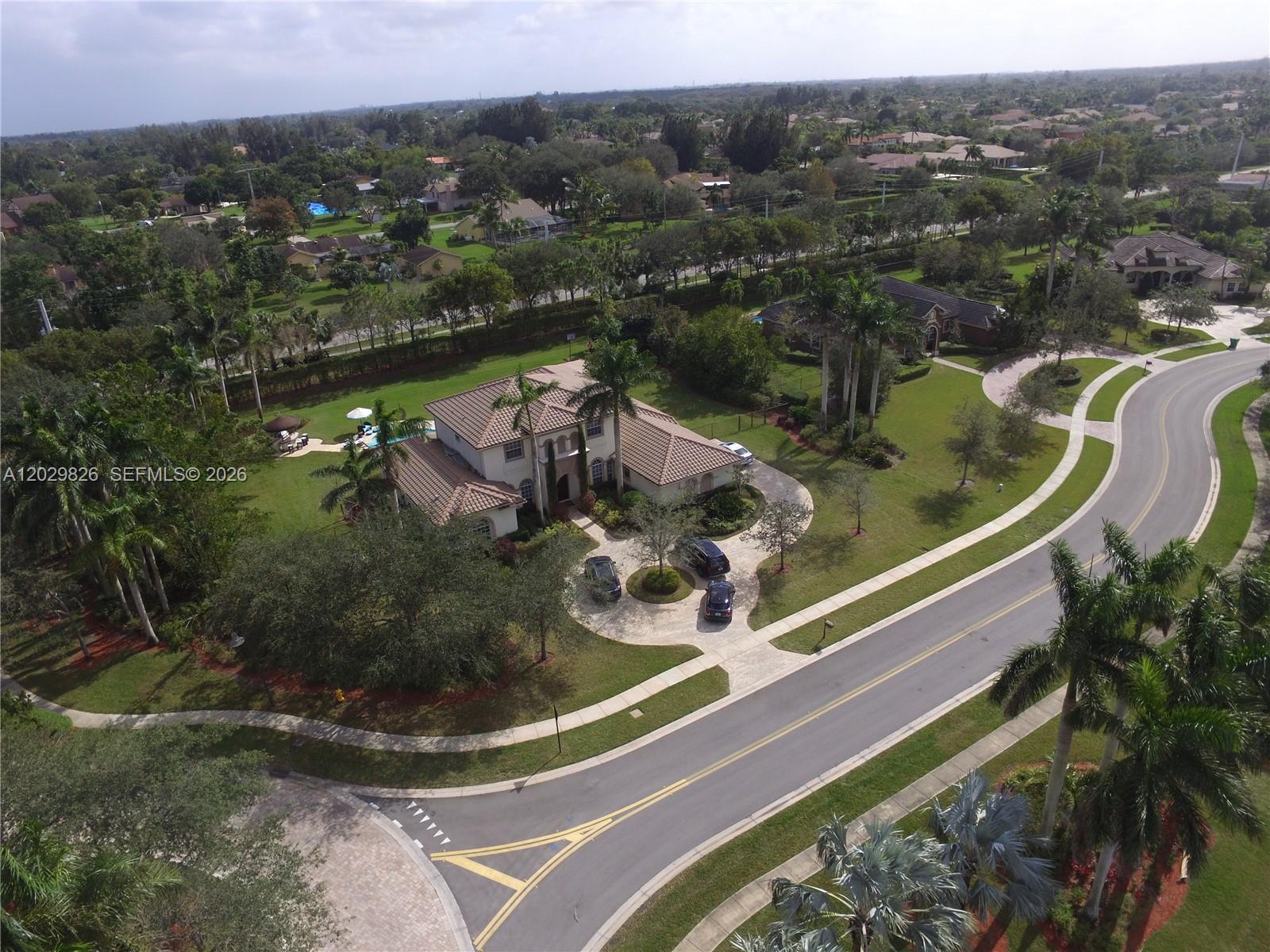 An aerial view shows a two-story house with a tiled roof and a circular driveway — 2750 E Jockey Cir E, Davie FL 33330, DAVIE, FL