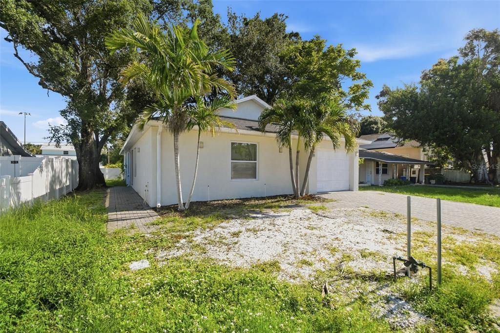 A single-story house with a white exterior, a paved driveway, and two palm trees — 2303 BAHIA VISTA STREET, SARASOTA, FL