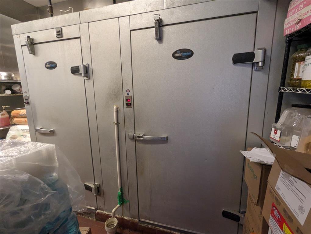 Two industrial walk-in cooler doors with metal finishes are positioned side-by-side in a commercial kitchen — 2430 US HIGHWAY 27 UNIT 380, CLERMONT, FL