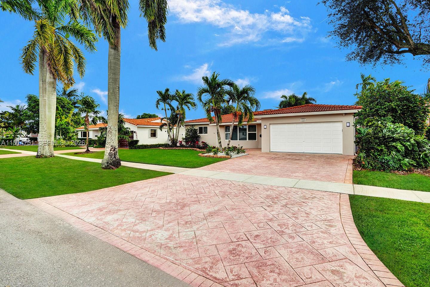 A single-story house with a white garage, tiled roof, and palm trees on a sunny day — 5500 Cleveland St, Hollywood FL 33021, HOLLYWOOD, FL