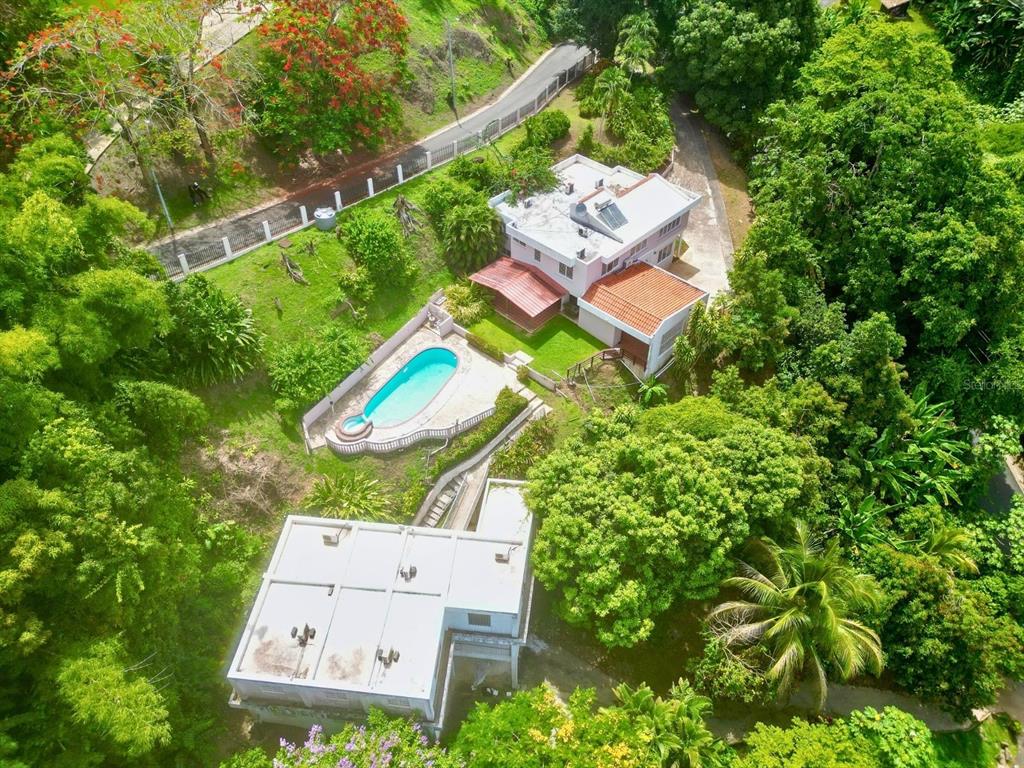 An aerial view shows a house with a pool, a separate structure, and lush landscaping — D 17 SUNSET HILLS, GUAYNABO, PR