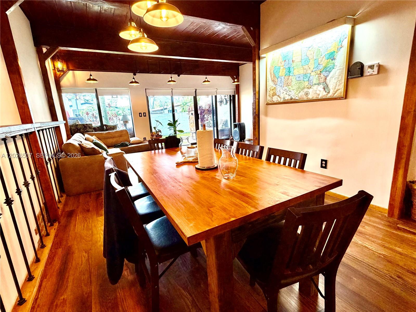 A dining room features a large wooden table, dark chairs, and a map on the wall — 19440 NE 26th Ave # 52B, Miami FL 33180, MIAMI, FL