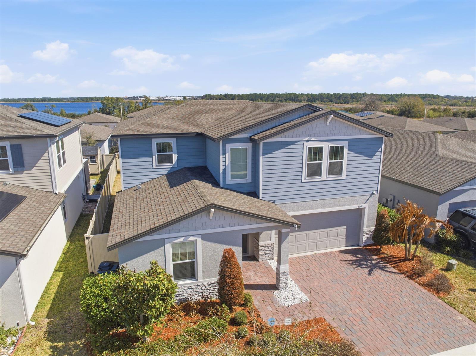 An aerial view of a two-story blue and gray house with a brick driveway — 3061 Cassidy Lane, FL 33844, FL