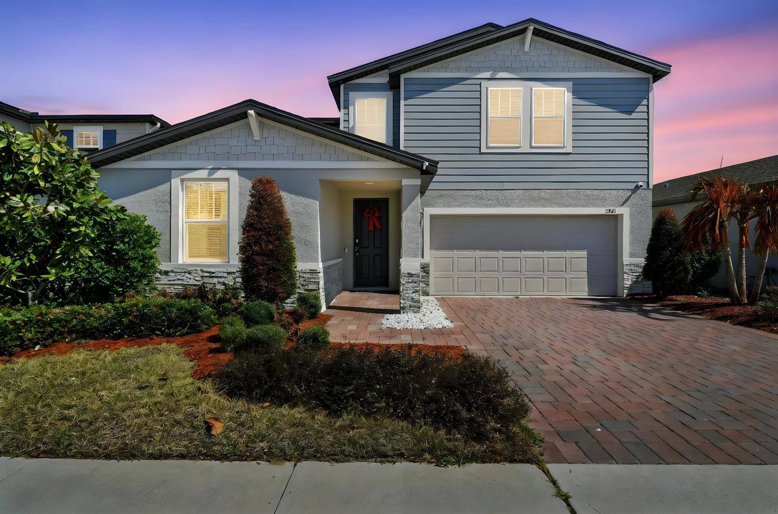 A two-story suburban house with blue siding, a brick driveway, and a front entrance — 3061 Cassidy Lane, FL 33844, FL