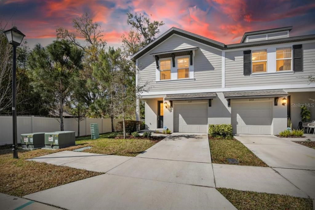 A two-story townhouse with light gray siding, a concrete driveway, and a one-car garage — 2710 SCARLET BAY PLACE, BRANDON, FL