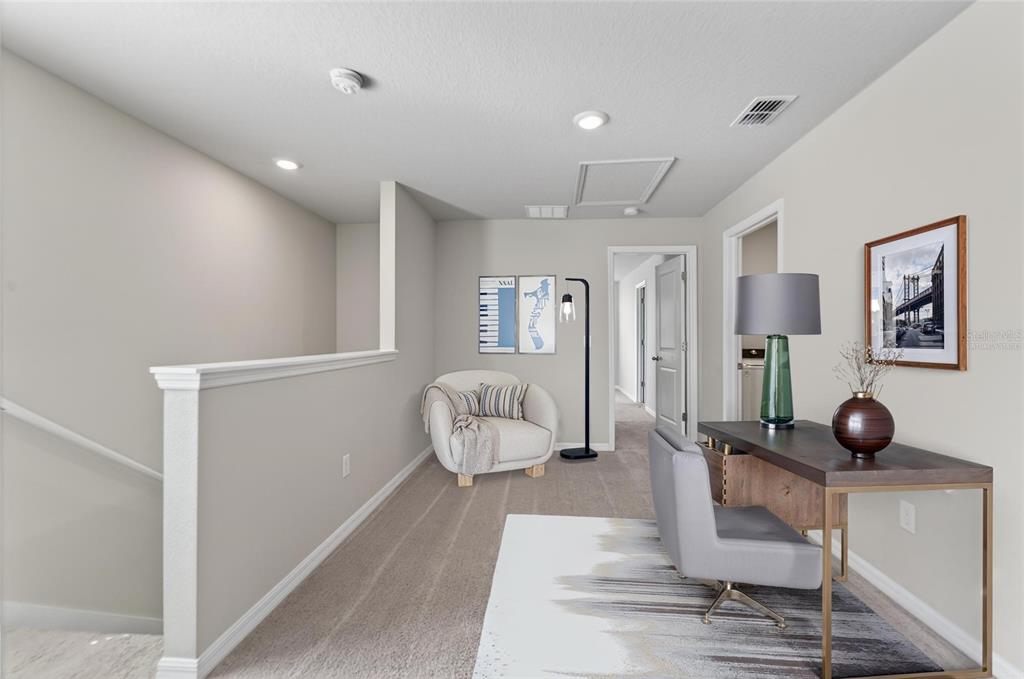 A carpeted home office area features a desk, an armchair, and a wall-mounted staircase railing — 2710 SCARLET BAY PLACE, BRANDON, FL