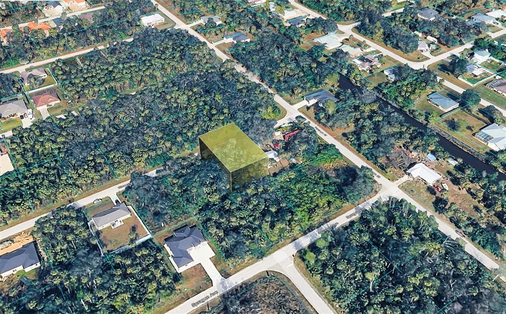 An aerial view shows a highlighted vacant lot surrounded by dense trees and residential homes — 16491 STRAUSS AVENUE, PORT CHARLOTTE, FL