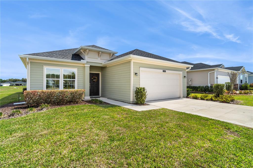 A single-story house with light green siding, a two-car garage, and a front lawn — 7381 SW 78TH TERRACE, OCALA, FL