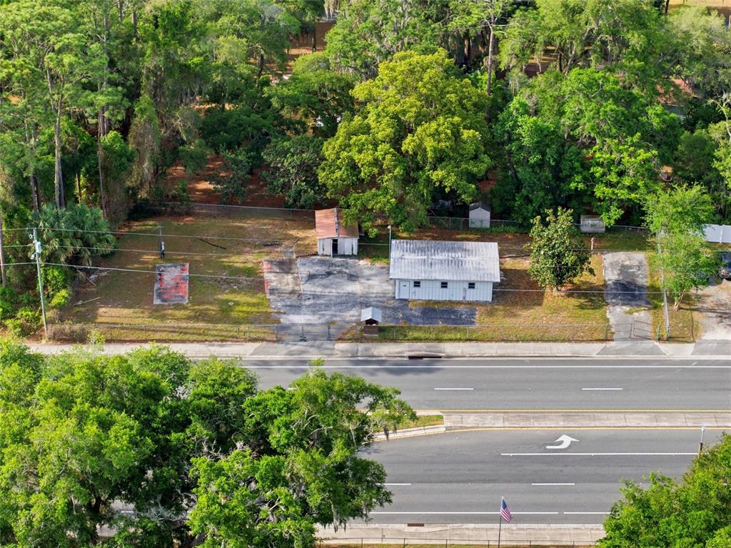 An aerial view shows a vacant lot with two small buildings and paved areas — 320 HIGHWAY 466, LADY LAKE, FL